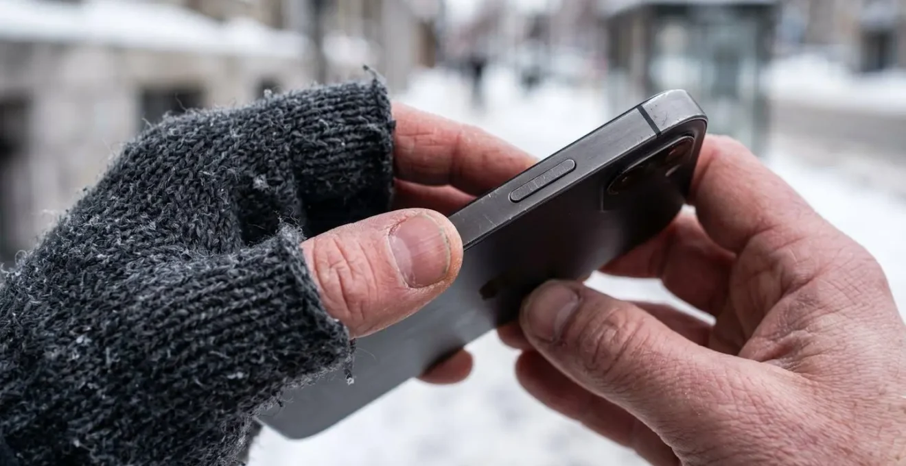 Person checking clinic wait times on mobile device in Montreal winter setting